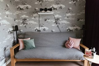 The walls of the cinema room/guest bedroom are covered with Seasons Autumn Cloud Forest. Because it’s a cinema room, Zeng and her husband knew they wanted a dark colored wallpaper to help minimize the light reflection from the projector. "We immediately thought of our Cloud Forest design. Full of drama, the surreal composition of plants floating between the clouds seemed like the perfect fit for a cinema room," she says.