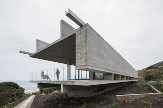 The walls and ceiling structure rest upon two longitudinal beams of the same length, which have been placed under the floor slab. The same four walls that support the ceiling extend past the floor slab to create the base level for the bedrooms on the south end of the house. 