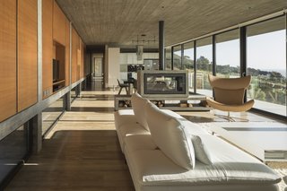 In the living areas, the inner surface of the massive beam-wall that frames the eastern façade is clad in wood, which adds a sense of warmth to counteract the coolness of the concrete.