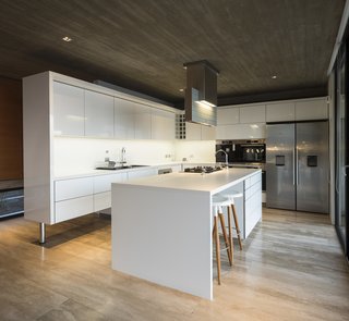 An all-white kitchen works well with the concrete to give the space a cool, minimalist look.