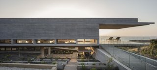 The concrete beams support four walls, while also extending beyond to create massive, 23-foot-long cantilevers at both ends of the structure. As a result, the profile of the home looks like the letter "H" in the horizontal position, levitating on a slope. 