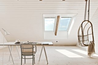 Set over two levels, the converted barn has been fitted with gray-framed windows that look out to the lush fields outside. 