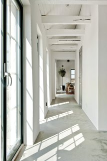 The kitchen and dining area have been designed as a single, open-plan space. This area now has a large antique table, Hans Wegner Y-chairs, and Danish-designed furniture. 