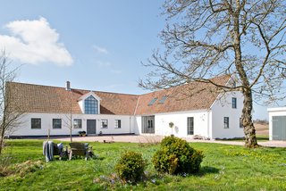 The home is sited on a flat expanse of farmland. When the current owner, Jonathan Andersson, first purchased the property, he hired a team of carpenters, plumbers, and electricians, and spent 14 months renovating. He and his team excavated around two feet of ground under the home and laid down drainage materials, cellular plastic, reinforcement, and a floor-heating hose before filling the areas with concrete.