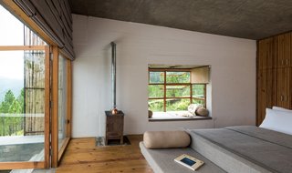 In the chalet room, the bed, table, and seating were designed as a island unit finished in smooth cement render. 