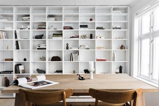 The second floor—where the common areas are located—has been designed as an open space with a kitchen island, a dining table, a wood burner, and a compact sofa near the window that’s perfect for two. 
