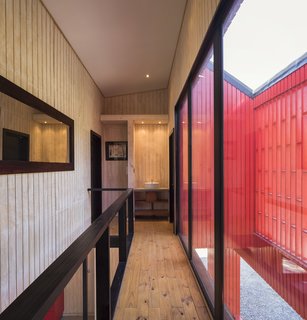 A hallway on the upper level leads to a bathroom and overlooks the front terrace.