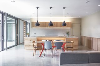 The ground floor consists of two zones—a northern wing where the open-plan kitchen, dining room, and living area are located, as well as a western wing, which houses the four bedrooms. 