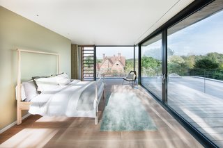 The south-facing master bedroom on the first floor has a terrace that opens to views of the countryside beyond the garden.