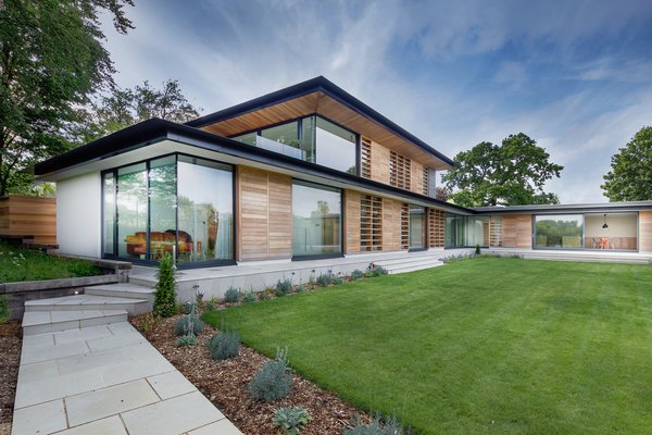 The two-story house is positioned adjacent to the massing of Manor Court so that the profile of its roof edge on the first and second floors align with the eaves and ridge of the property.