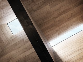 The skylights on the peaked roofs, along with the pivoting glass doors and windows, enhance the cabin’s modern, sculptural form.