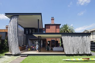 They wanted their new home to better connect with the surrounding garden site, and include a sheltered outdoor space that would allow them to dine comfortably outdoors even in the hot summer months.