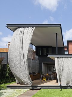 Gibson opened up the interiors to create an "engawa," an edging strip of non-tatami matted flooring in Japanese architecture, that he then enclosed in a steel mesh curtain.