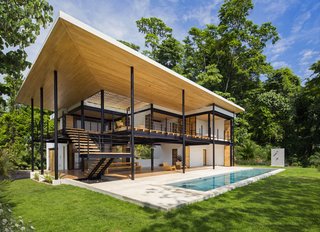Sited on the back of a steep hill, the house is a lightweight and exposed structure with enclosed private rooms at the rear that transition into more open terraces in the front to capture the stunning surrounding views. 