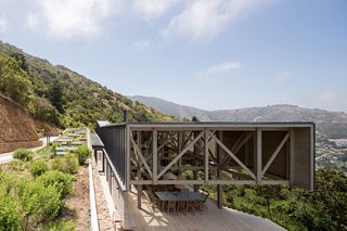 This volume has a rough hewn façade of stacked stones, and a green roof that seems to meld with the green hills of the surrounding El Boldo Park.