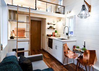 Beyond the living room is a kitchen with pullouts, closets, full-size tiny appliances, and a large Ruvatti sink. 