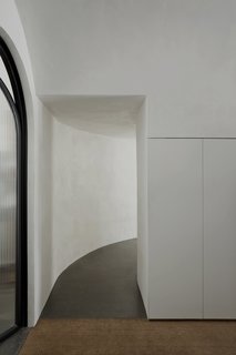 The low ceilings create a sense of darkening and narrowing, which contrasts with the voluminous, bright main room at the end of the corridor. The results bring to mind the play of light and shadow in the owner's love for chiaroscuro paintings. 