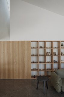 "The asymmetrical volume, enveloping form, chiaroscuro effect of the curved corridor, shadows, margins, thresholds, voids, and raw materials allow the unique atmosphere of the place to emerge without concealing the structural logic of the house," says Antonio Di Bacco of Atelier Barda.