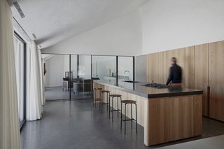 The inclined, faceted ceiling, light cannon in the ceramic studio, and vertical veils give the interiors a sculptural quality.