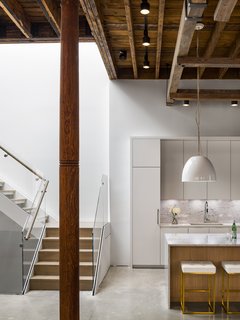 A white metal staircase leads up to the master bedroom. 