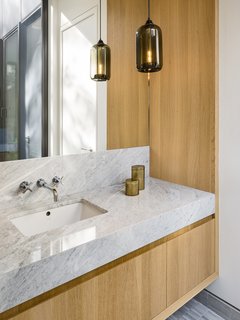 Bleu de Savoie and Thassos marble and glass tiles complement the natural warmth of the polished concrete and white oak floor, as well as the Italian millwork.
