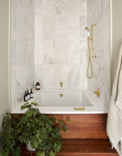 A luxurious bathtub with marble walls.