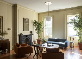 This room houses a Lawson Fenning Moreno sofa and lounge chairs, an antique mosaic-horn coffee table, and Workstead Signal globe and sconce lights.