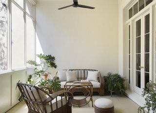 A vintage bamboo outdoor sofa, lounge chairs, and a coffee table sit together in the Veranda.