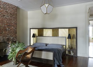 A Lawson Fenning cane bed, Selig night stands with fabric sling, an antique screen, and an antique barrel chair are in the master chambers.