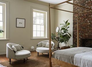 The guest bedroom on the third floor has a shaker style, tiger-maple canopy bed, Adrian Pearsall lounge chairs, and an antique shaving stand.