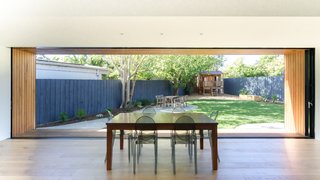 The expansive sliding glass doors in the main living area frame panoramic garden views. The deep timber extensions around the windows can now be used as bench-style seating to bring the family out into the garden, while the top eaves serve as shades to reduce heat from the strong sun exposure.