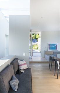 The family wanted a house that felt like a traditional bungalow. The architects achieved this by creating a low opening at the rear terrace, with low pivot and sliding doors that can be opened throughout the house to frame views of the ocean.