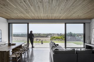 The two pavilions are fitted with large sliding glass doors, which open to two wooden decks. Here, views are oriented toward the peaceful natural landscape and sea beyond. 