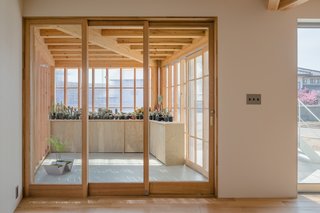 The high ceilings, natural light, and custom-made wooden furniture give the house a simple, fresh, and clean feel. 
