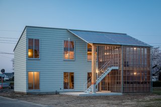 Constructed with wood and Perspex acrylic glass, this semi-transparent volume extends from the side of the main house, blurring the boundaries between indoors and outdoors.