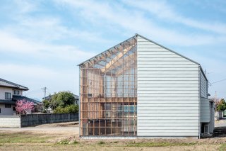 This creates the appearance of a singular gabled house with opaque walls on one side and transparent walls on the other. 