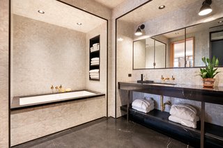 The master bathroom features a custom-designed vanity with bronze legs, a walk-in steam shower, multiple storage cabinets, and oil-rubbed bronze fixtures by Lefroy Brooks.
