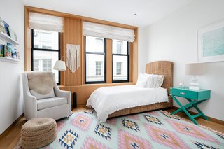 To the north of the "great room" is a second bedroom, which has a wall of closets and drawers clad in oak millwork.