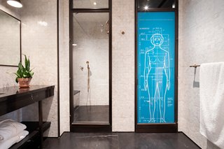 Slabs of Nero Marquina marble cover the walls of the master bathroom.