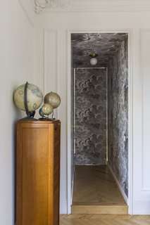 A narrow hallway leads to the bedroom. As you can see, the movement from light colors to dark creates a bold, dramatic aesthetic.