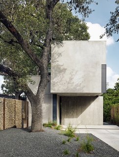 This massive Durand oak tree inspired the design of the house. Thanks to a wall of welded steel and tumbled limestone, the home has an abundance of privacy. 