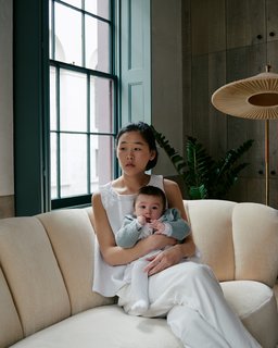 Zoe Chan Eayrs and her daughter Max relax on a Danish banana sofa that Chan + Eayrs reupholstered in Cream Pierre Frey velvet.