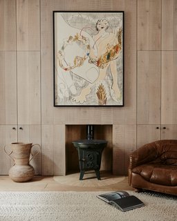 The antique Norwegian log burners in the living room are framed within semicircular hearths made of radial clay bricks. 