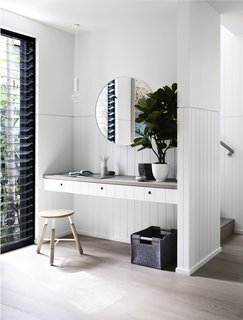 New black-framed windows capture the views of the palm trees' long branches.