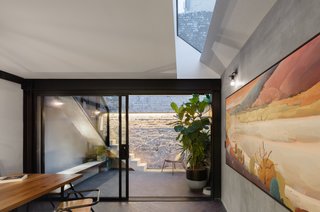 In the courtyard, narrow concrete stairs wrapped in steel filigree leads up to another courtyard located at the rear of the upstairs bedroom.