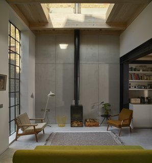 The living spaces on the ground floor now consist of exposed steelwork with polished concrete, timber surfaces, and large Crittall windows.
