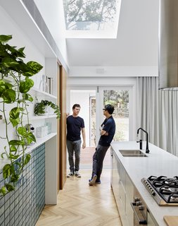Along the edge of the outdoor deck, reclaimed red bricks complement those used in the neighboring houses.