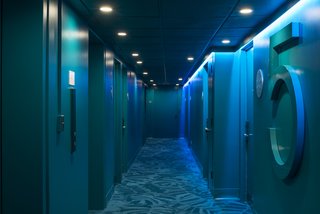 A mood-lit hallway leads to the rooms.
