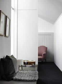 The architects have added cement cladding with aluminum-framed windows above and besides an existing brick wall to create a framework with a stable base and a lightweight upper section.