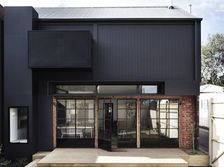 Recycled and repurposed items, such as salvaged bricks and a stainless steel bench from a commercial kitchen, have been used to create a low maintenance and sustainable home.